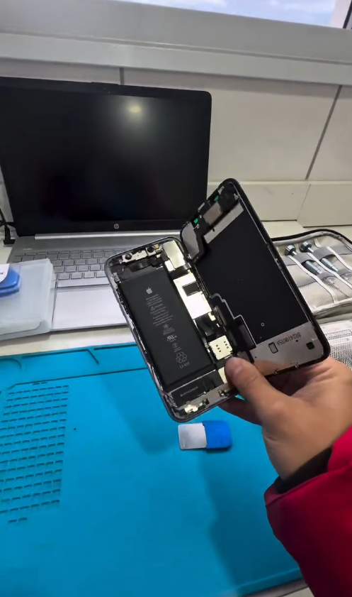 iPhone aberto em bancada técnica